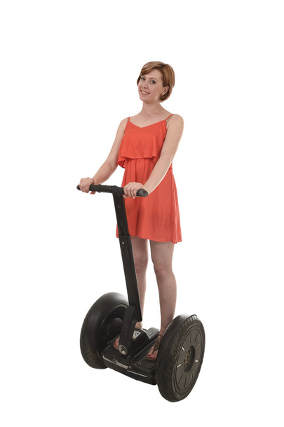 young attractive tourist woman in chic summer dress smiling happy riding electrical segway - Fotó, kép
