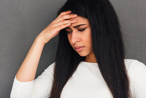 Frustrierte junge Frau berührt Stirn  - Foto, Bild