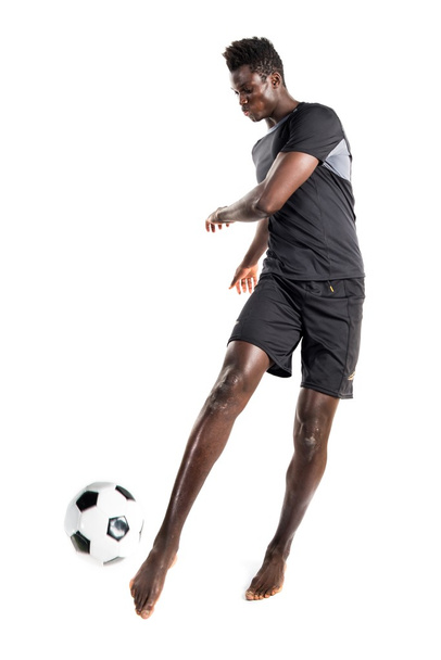 Musta mies pelaa jalkapalloa
 - Valokuva, kuva