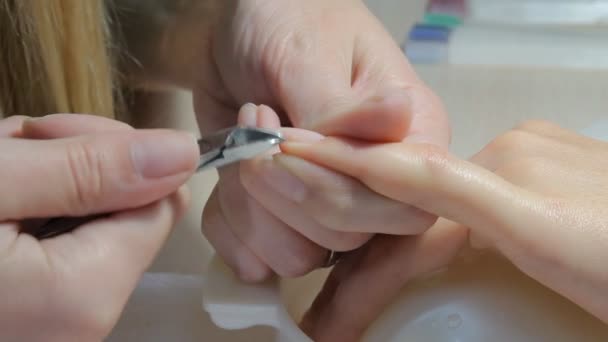 Technicus geven de klant een manicure op nagel salon nagel. Jonge vrouw ontvangen op een Franse manicure. - Video