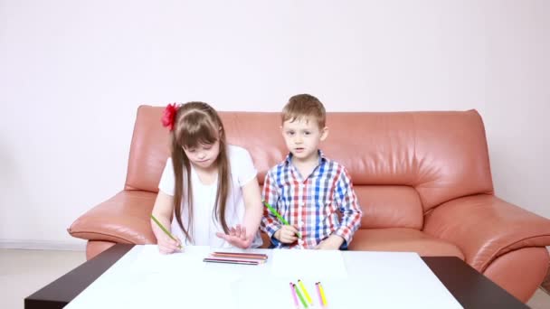 zwei entzückende glückliche Kinder, die im Kindergarten mit Buntstiften zeichnen. Mädchen mit Down Syndrom. Rehabilitation von Behinderten - Filmmaterial, Video