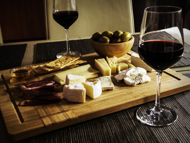 Camembert, Gouda And Brie Cheese Platter With Wine Glasses - Фото, изображение