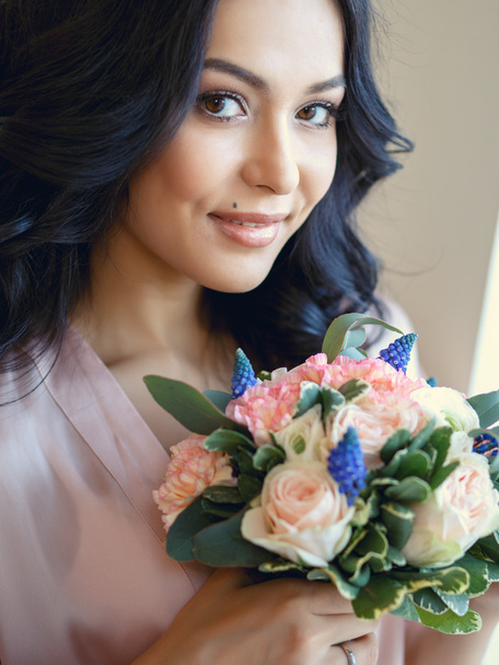 Close-up portrait of beautiful brunette bride before wedding, holding bridal bouquet in a morning - Zdjęcie, obraz