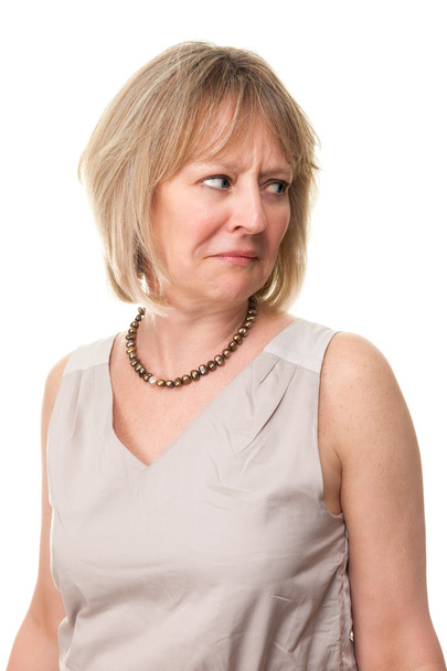 aantrekkelijke volwassen vrouw kijken over de schouder met bezorgd expre - Foto, afbeelding