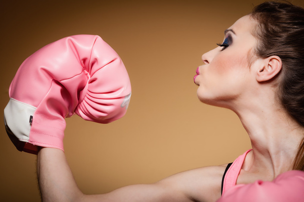 Female boxer wearing big fun pink gloves playing sports - Foto, afbeelding