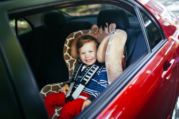 Schattige babyjongen in veiligheid autostoel.  - Foto, afbeelding