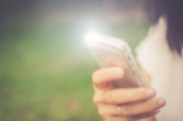 Blur woman using smart phone in park abstract background.  - Fotó, kép