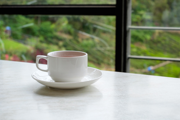 Белая чашка чая на белом мраморном столе в чайном магазине
 - Фото, изображение
