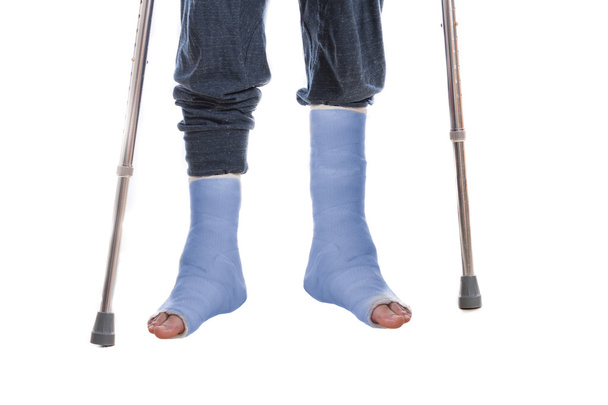 Twee blauwe been afgietsels en krukken - Foto, afbeelding
