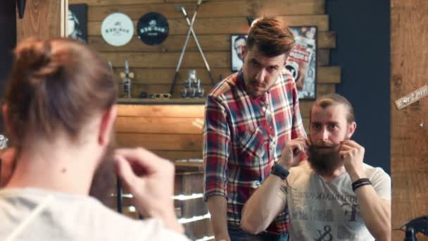 男は鏡の中の彼のひげをカットする方法を示す - 映像、動画