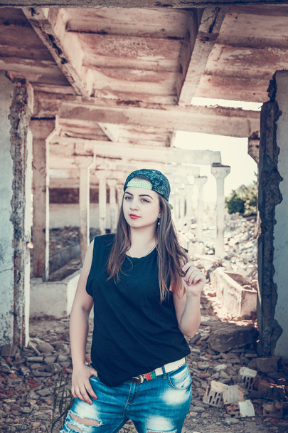 Femme attrayante en jean et en tasse posant dans une vieille maison d'usine en ruine
. - Photo, image