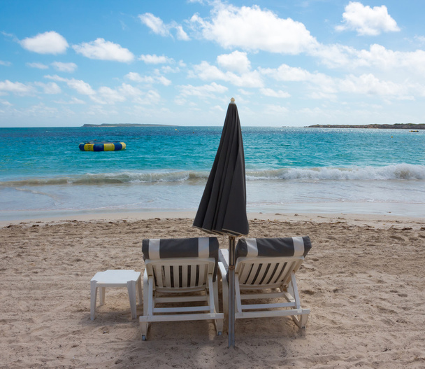 Duas cadeiras e guarda-chuva na praia tropical
 - Foto, Imagem