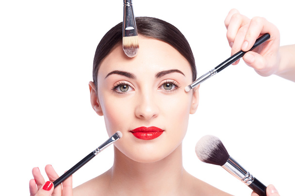 Cheerful healthy girl is doing facial make-up - Foto, imagen