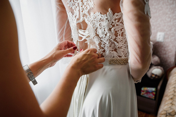 druhna wiązanie wstążki na ślubnej białej sukni - Zdjęcie, obraz
