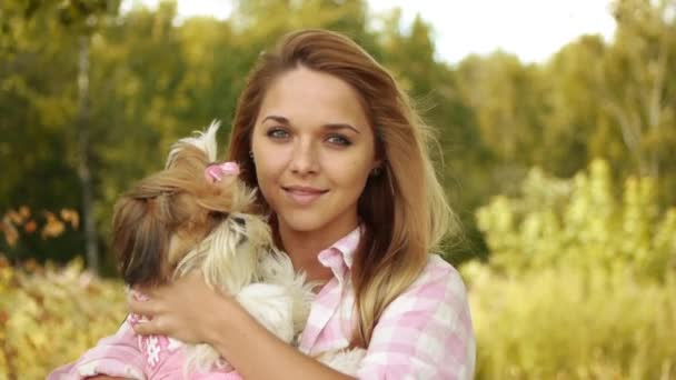 Oldukça genç gülümseyen kadın tutarak küçük kabarık köpek, yaz yeşil park çerçevede portresi - Video, Çekim