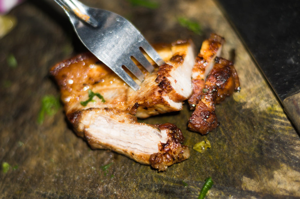 Porc rôti sur une vieille planche à découper avec fourchette
 - Photo, image