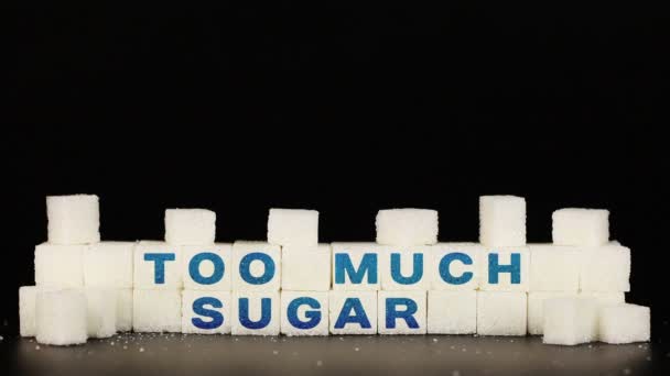 Mans hand puts sugar cubes on which is inscription the word too much sugar - Footage, Video