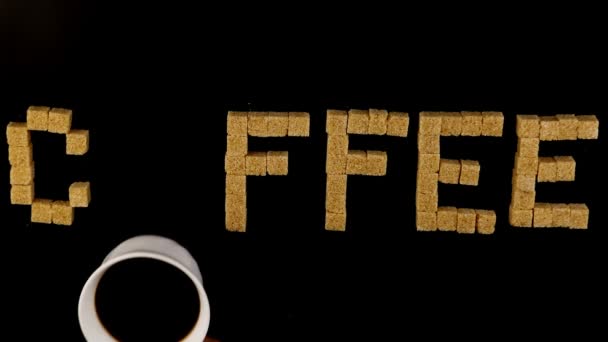 Manos de hombre poniendo una taza de café en la palabra café escrito por cubos de azúcar
 - Metraje, vídeo