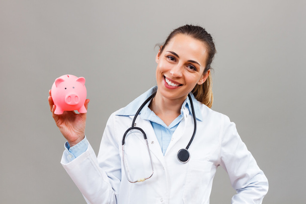 female doctor holding piggy bank - Zdjęcie, obraz