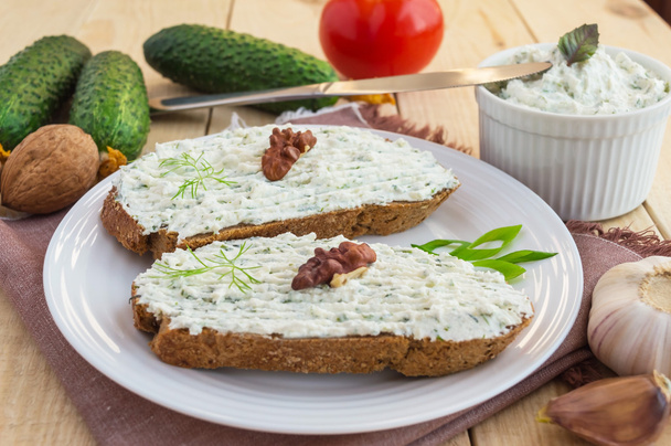 Sandwich nutritif avec pâte de fromage cottage sur pain de seigle sur une assiette blanche
 - Photo, image