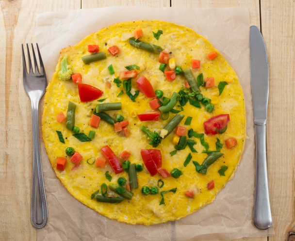 Omelette mit Gemüse auf einem hölzernen Hintergrund. Frühstück - Foto, Bild