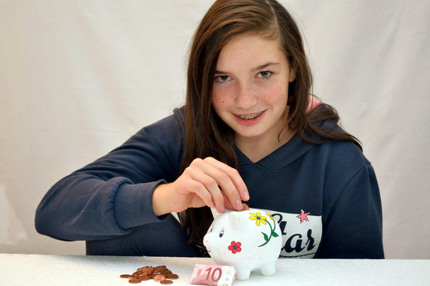 Teenagers throwing coin into the piggy bank - Photo, Image