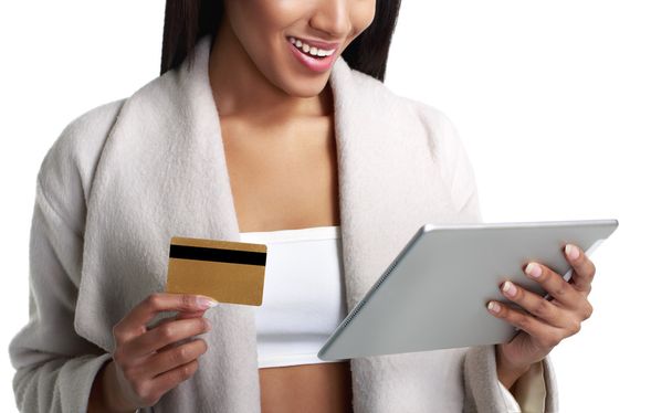Mulatto black woman holding digital tablet computer and pay from gold credit card. Close-up view. Isolated on white. - Fotoğraf, Görsel