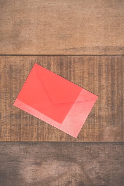 Grunge red envelope on wooden background - Fotoğraf, Görsel