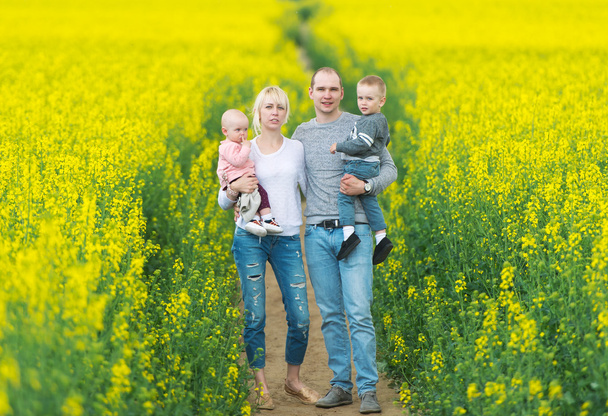 Happy family have a rest on the yellow rape field. - Photo, Image