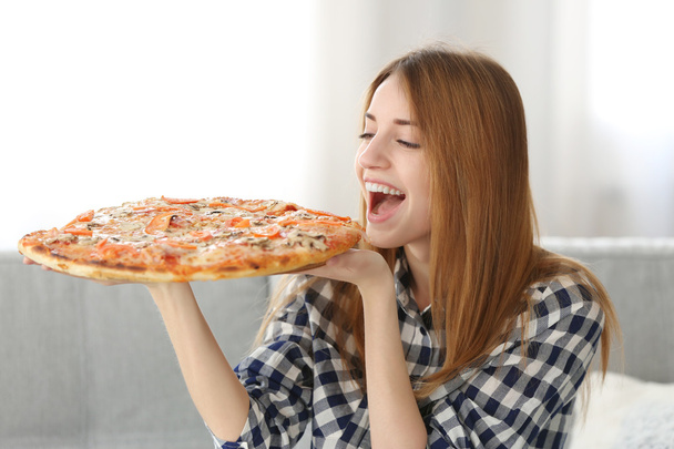 Happy young woman holding pizza - Photo, Image