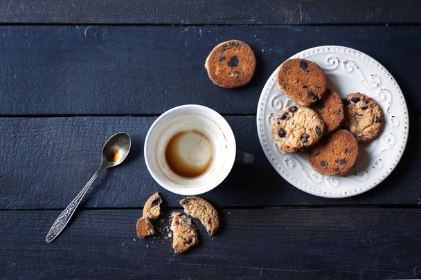 Empty coffee cup with cookies on wooden table - Foto, afbeelding