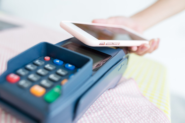 Kobieta za pomocą telefonów komórkowych za zapłacenie rachunku - Zdjęcie, obraz