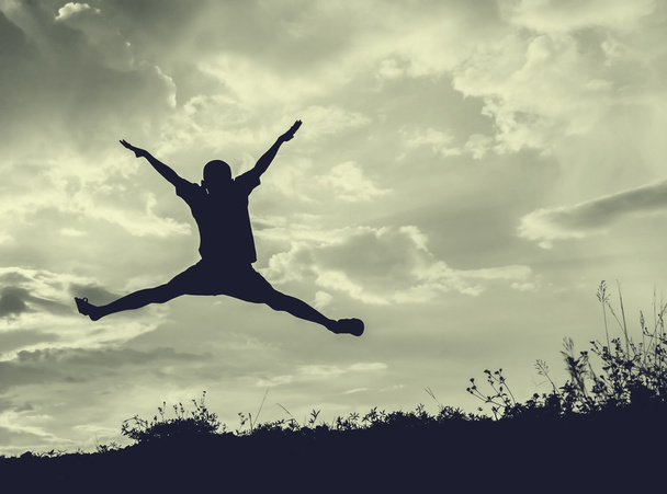  pieni poika hyppäämällä taivaalle ja ottaa onnellinen aika, Sillhouette käsite
 - Valokuva, kuva
