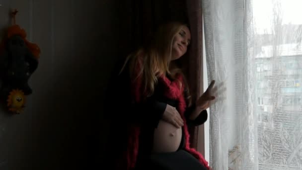 A pregnant woman sitting near the window. - Záběry, video