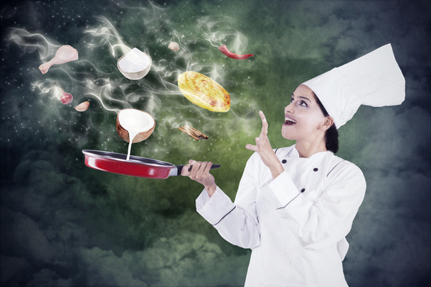 Female chef cooking with magic - Foto, afbeelding