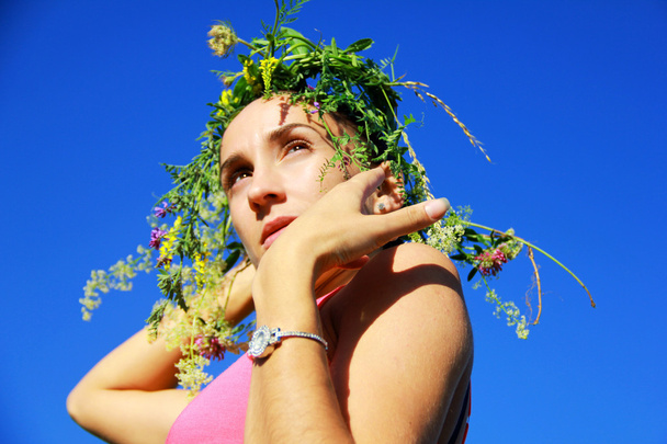 the girl in a wreath from flowers - Foto, afbeelding