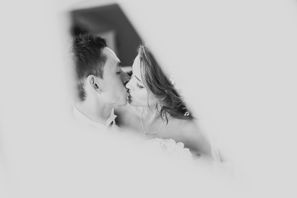 wedding couple is standing and kissing in hotel - Foto, Imagen