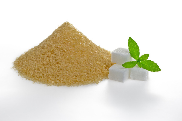 Stevia verlaat met suikerklontjes en een bruine suiker heap - Foto, afbeelding