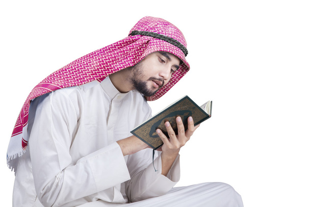 Middle eastern man reads Quran in studio - Foto, imagen