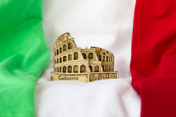 Figur Kolosseum vor dem Hintergrund der Flagge Italiens. - Foto, Bild
