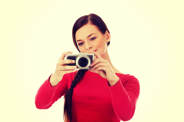 Pretty woman taking a photo using classic slr camera - Photo, image