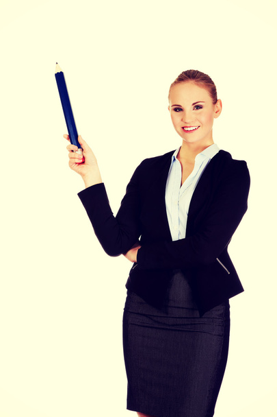 Business woman pointing for copyspace or something with huge pen - Photo, image