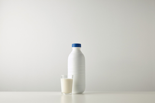 plastic white bottle near glass with milk - Foto, Imagem