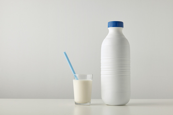 glass with organic milk near plastic bottle  - Фото, зображення