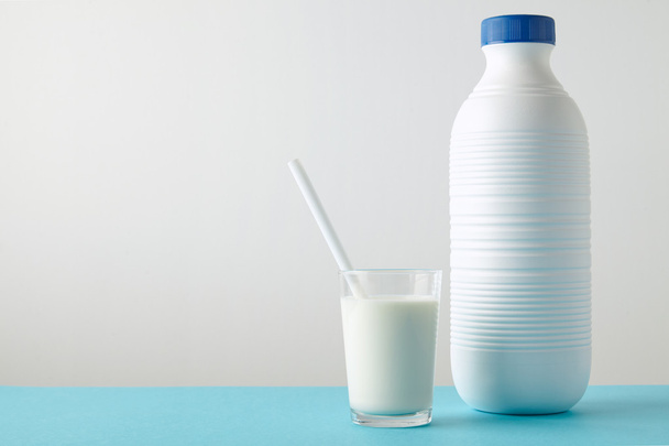 glass with organic milk near plastic bottle  - Photo, Image