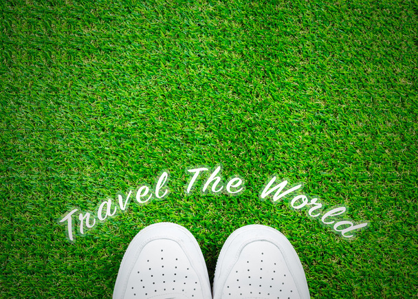 Travel the world text on grass with shoes; travel concepts backg - Photo, Image