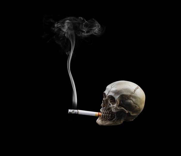 Crânio humano fumar um cigarro no fundo preto
. - Foto, Imagem