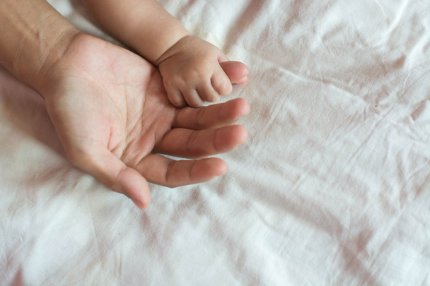 Holding baby Hands with mom - Foto, afbeelding