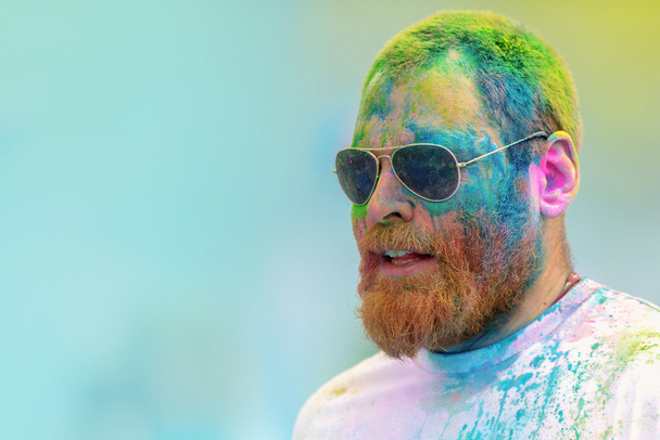 Kolorowa twarz męskiego uczestnika z brodą w ostatnim niebieskim St - Zdjęcie, obraz
