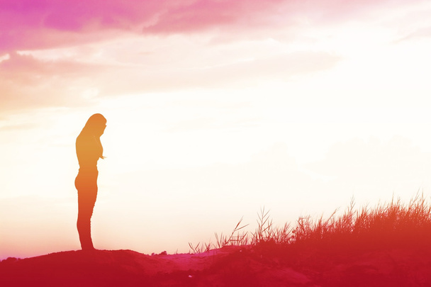 Frau steht allein auf dem Feld bei schönem Sonnenuntergang - Foto, Bild